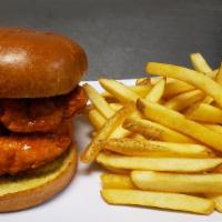 Spicy Chicken Sandwich · Fried chicken tenders tossed in buffalo sauce, topped with moon sauce and pickles on a brioc...