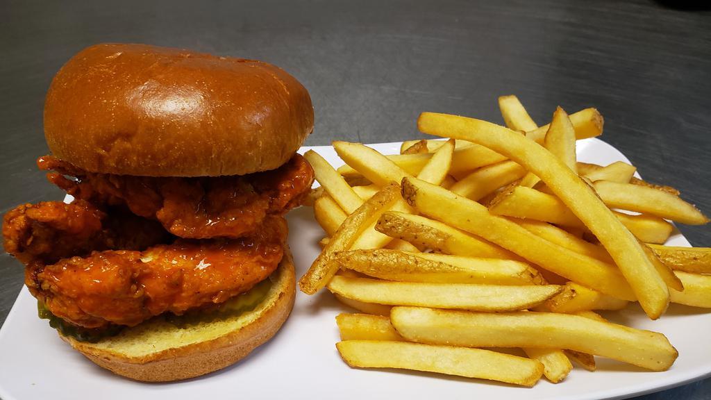 Spicy Chicken Sandwich · Fried chicken tenders tossed in buffalo sauce, topped with moon sauce and pickles on a brioche bun.