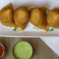 Samosas · Fried pastry with a savory filling of spiced potatoes and green peas. A pocket bursting with...