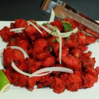 Chicken 65 · A spicy deep-fried appetizer, garnished with onions and cilantro.