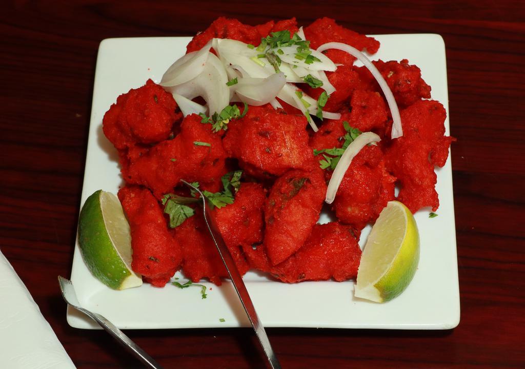 Fish 65 · A spicy deep-fried appetizer, garnished with onions and cilantro.