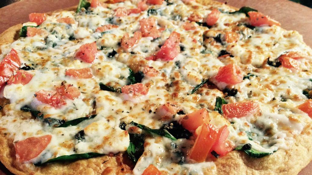 Margherita Crisp · Sun-dried tomato tortilla brushed with olive oil & covered in garlic, basil, spinach, 100% mozzarella, diced tomatoes & Parmesan oregano.