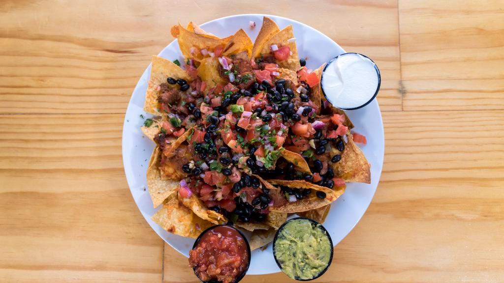 Nachos Grande · Tortilla chips smothered in melted cheese, onions, sour cream, jalapeños, diced tomatoes, and black beans. Add chicken, guacamole, or chili for an additional charge.