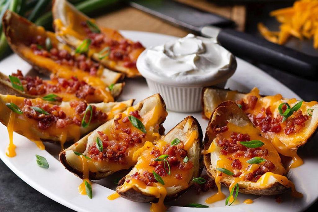 Made-From-Scratch Loaded Potato Skins · Topped with melted cheddar cheese, bacon bits and green onions served with sour cream.