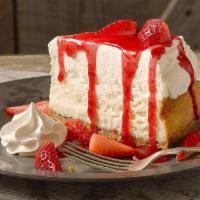 Roadhouse Cheesecake · Creamy New York style cheesecake drizzled with strawberry sauce and topped with fresh strawb...