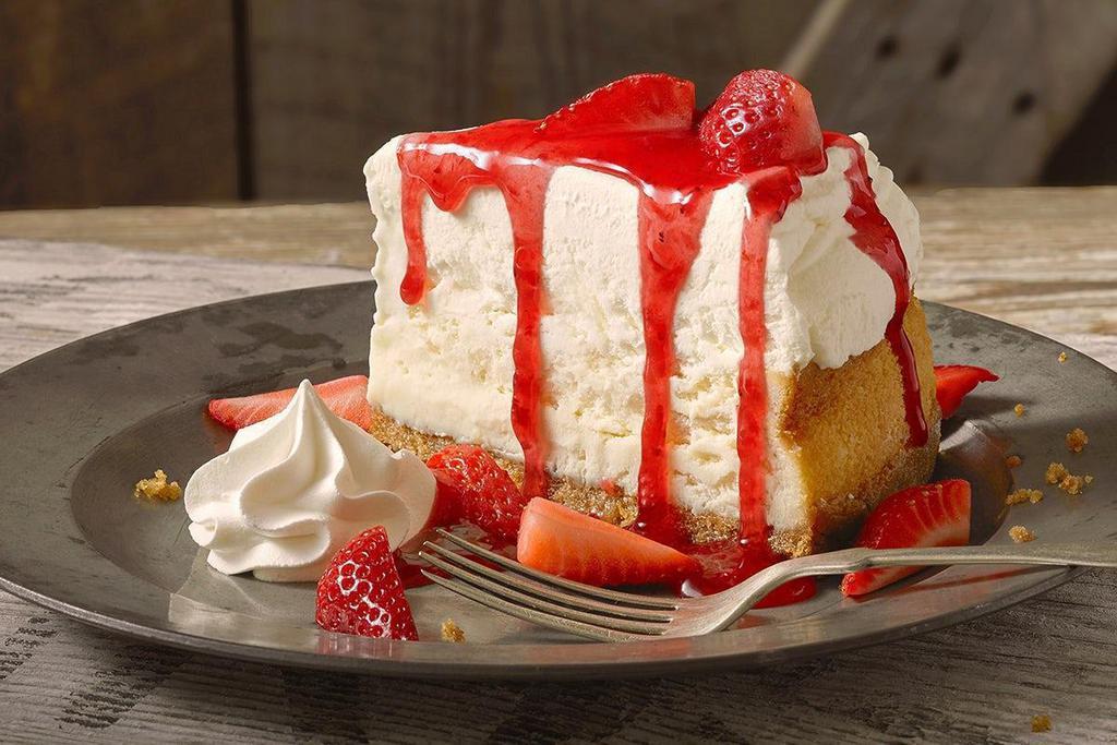 Roadhouse Cheesecake · Creamy New York style cheesecake drizzled with strawberry sauce and topped with fresh strawberries.