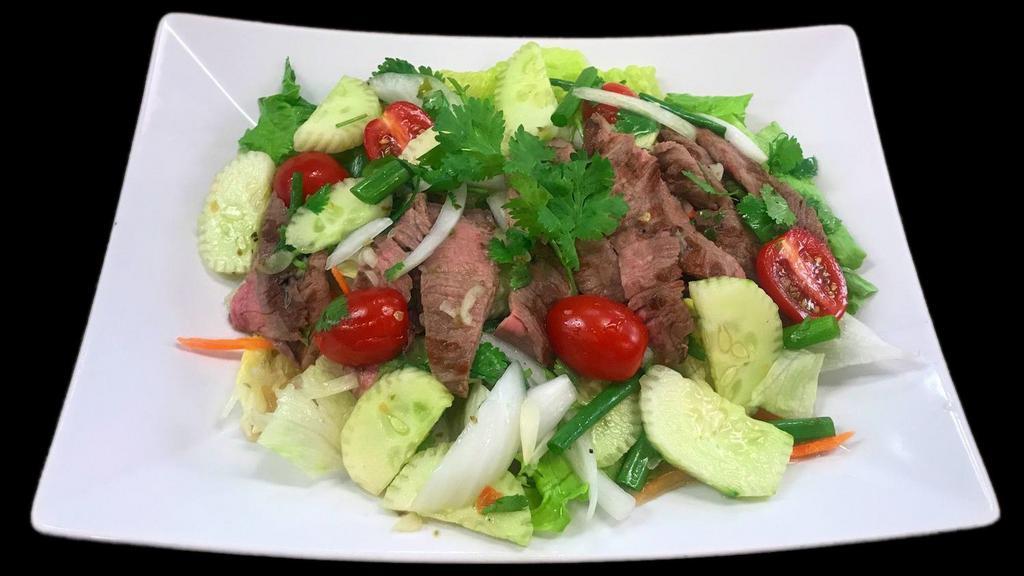 Thai Spicy Beef Salad · Slices of grilled tender beef dressed with Thai spicy lime sauce, garlic, chillies, cucumbers, tomatoes, onions, scallions and cilantro on crispy lettuce and carrots.