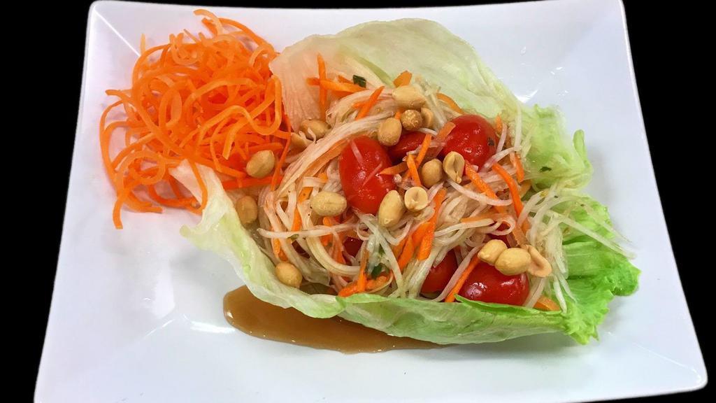 Papaya Salad (Som Tum) · Shredded green papaya, carrots, tomatoes and peanuts tossed in Thai special lime juice with garlic and chillies. Served on lettuce leaf.