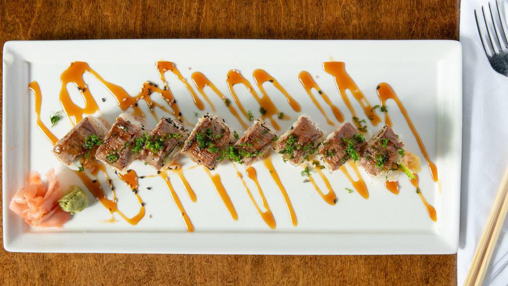 Blue Devil Roll · Shrimp tempura and cucumber topped with seared filet mignon, eel sauce and scallions.