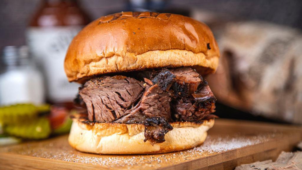 Smoked Brisket Burger · Savor of the rich flavor in this tasty original, an all brisket slow-smoked patty with 2 slices of cheddar cheese, 2 strips applewood smoked bacon, quotes sauce, lettuce, onions and pickles on a sesame seed brioche bun.