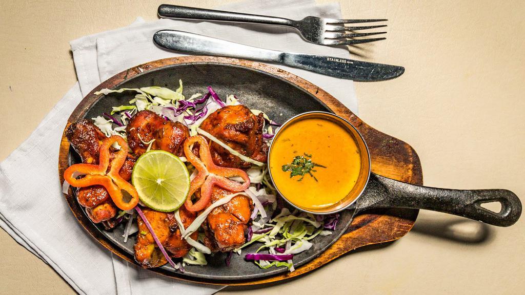 Tandoori Chicken · Gluten-free. Spicy. Chicken marinated in spices with yogurt and slow-cooked in clay oven.