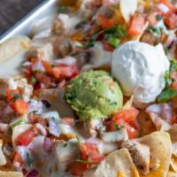 Beer-Braised Pork Or Chicken Nachos · House-prepared corn tortilla chips topped with pork or chicken, melted cheddar, pico, sour c...