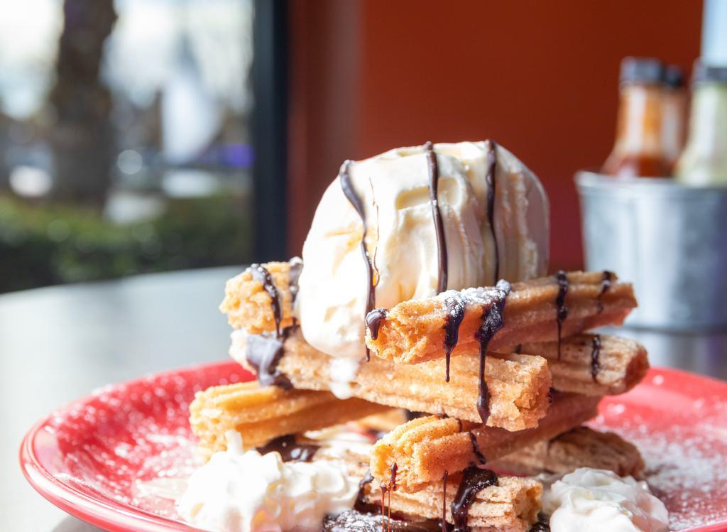 Churros · Fried pastry tossed in cinnamon, piled high!  Vanilla ice cream, chocolate sauce, Mexican syrup, whipped cream, powdered sugar.