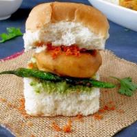 Vada Pav · The dish consists of a deep fried potato dumpling placed inside a bread bun sliced almost in...