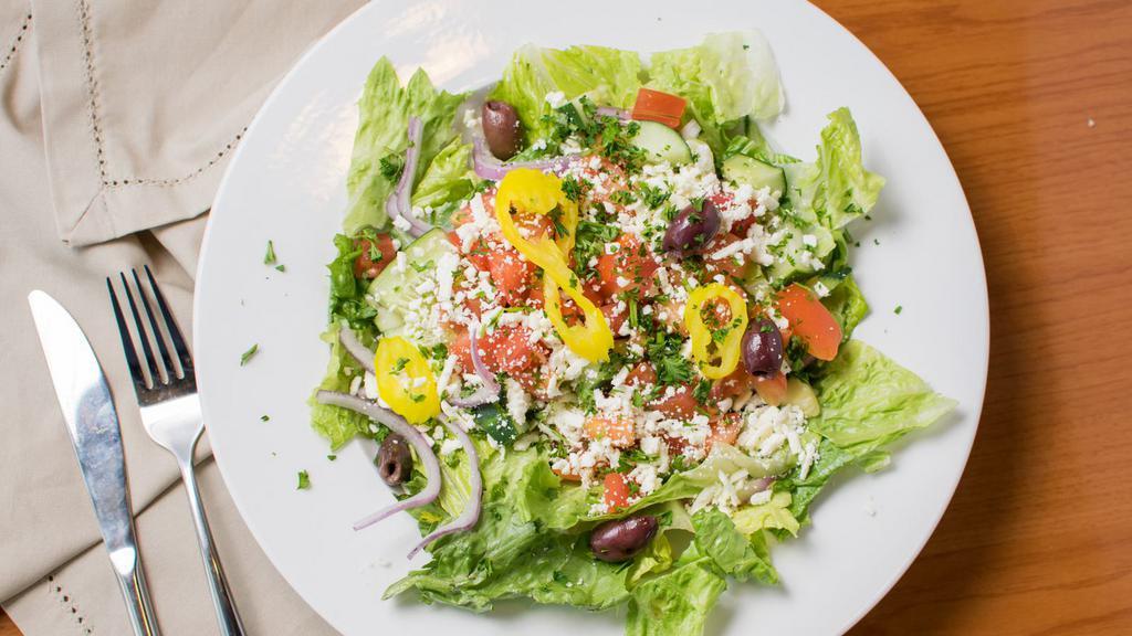 Greek Salad · Romaine lettuce, red onions, tomato, green peppers, cucumbers, olives & banana peppers with Mediterranean dressing with feta cheese & black olives.
