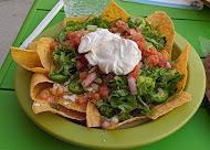 Nachos · tortilla chips, shredded chicken or picadillo ground beef, queso dip, sour cream, beans, lettuce, pico de gallo, queso fresco