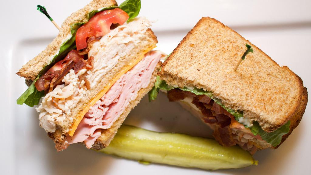 Classic Club · Three layers on toasted wheat - smoked ham, cheddar cheese, turkey, crisp bacon, lettuce, and tomato with honey mustard and mayonnaise.