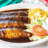 Enchiladas Poblanas · Four chicken enchiladas topped with mole poblano sauce, served with rice and salad.