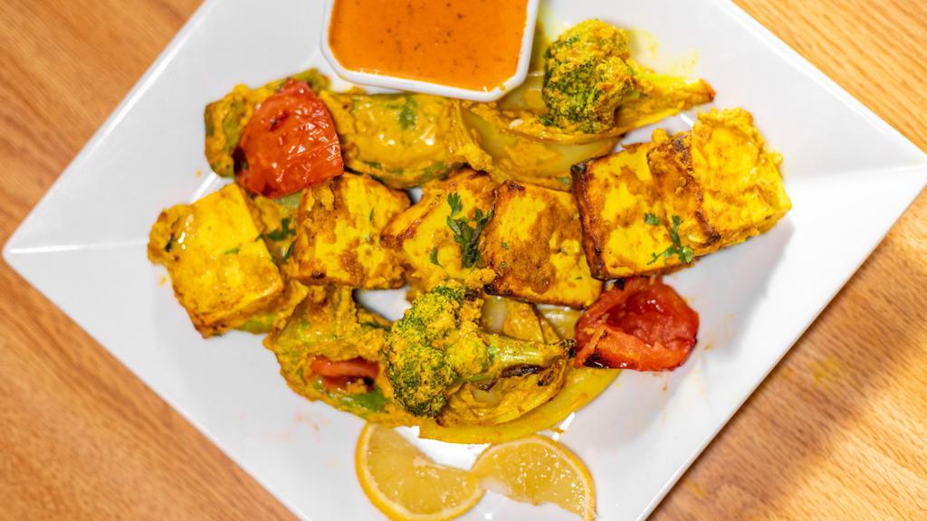 Paneer Tikka · Cheese cubes, peppers, onion and tomatoes. Tandoor is a clay oven, marinated freshly baked to order served on sizzler with fresh cut veggies, low fat herb yogurt or tikka masala sauce on side. Served with choice of rice. Gluten free.