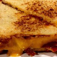 Rockhouse Grilled Cheese · A loaded grilled cheese featuring bacon ham and tomato on wheatberry toast.