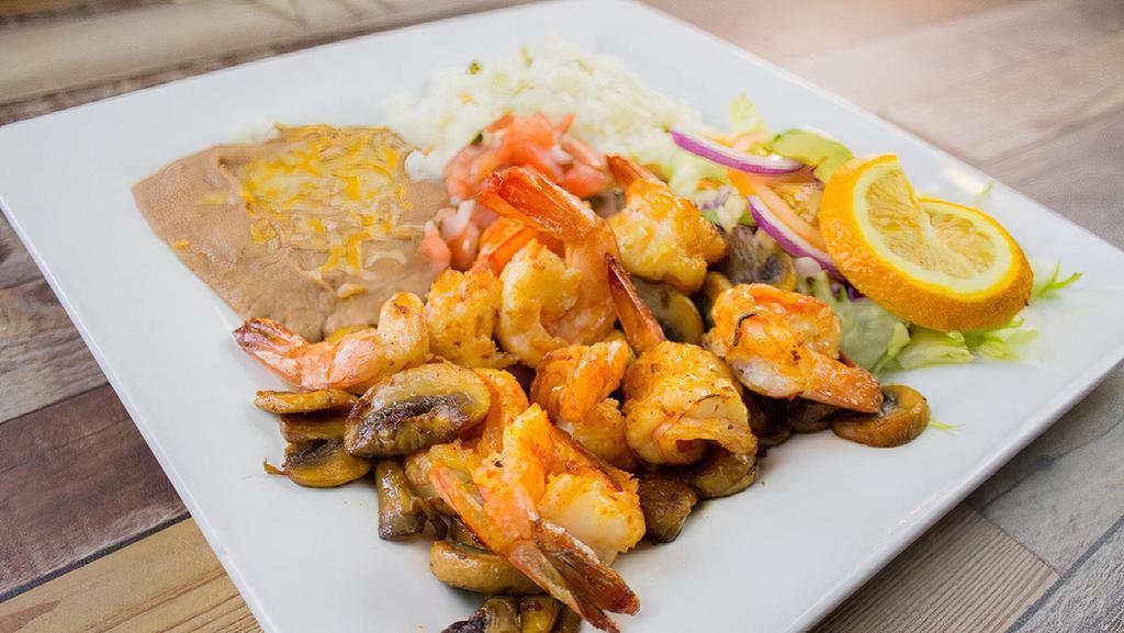 Camarones Con Hongos · Large prawns sautéed with garlic butter , mushrooms , covered with mojo de ajo sauce served with rice and beans .