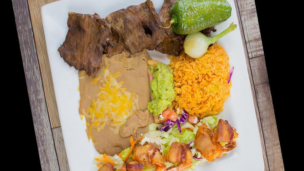 Carne Asada * · Grilled steak served with rice , beans , guacamole , onion and jalapeño .