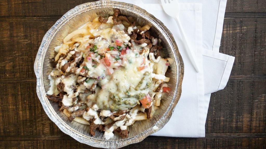 Carne Asada Fries · Our delicious California style fries, topped with diced steak, cheese, pico de gallo, guacamole, and sour cream.