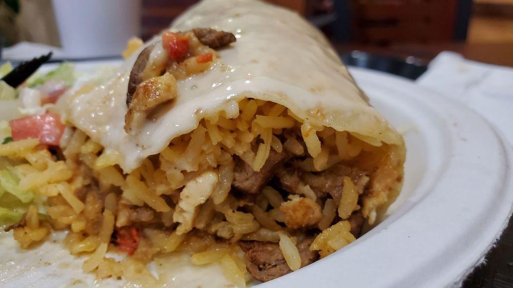 Burrito Texano · A large flour tortilla stuffed with steak, shrimp, chicken, rice, and beans covered with cheese sauce with a side salad, sour cream, and pico de gallo.