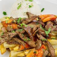 Lomo Saltado · Tender strips of steak, roma tomatoes and red onions sauteed and served over french fries wi...
