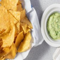 Chips Con Guacamole · A creamy dip made from avocado served with tortilla chips.
