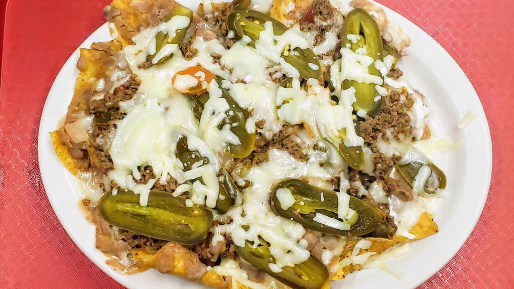 Nachos Texanos · Choose chicken or beef, covered with beans, cheese, and sliced jalapeños on corn tortilla chips.