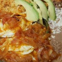 Huevos Rancheros Combo · Fried eggs mix in tomato sauce with sliced grill onion, peppers, rice, beans, tortillas, and...
