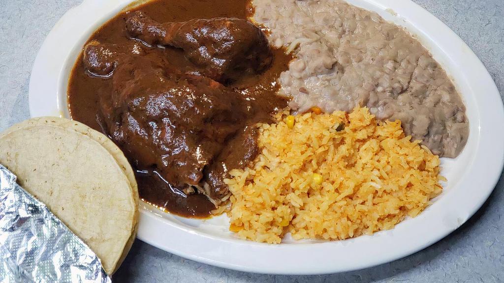 2Pz Pollo With Mole · Our pollo con mole is our rotisserie chicken covered in our rich thick mole sauce. Mole is made with peanuts, dark chocolate, and other spices and whole chilies. Served with rice, beans, tortillas, and hot sauce on the side.