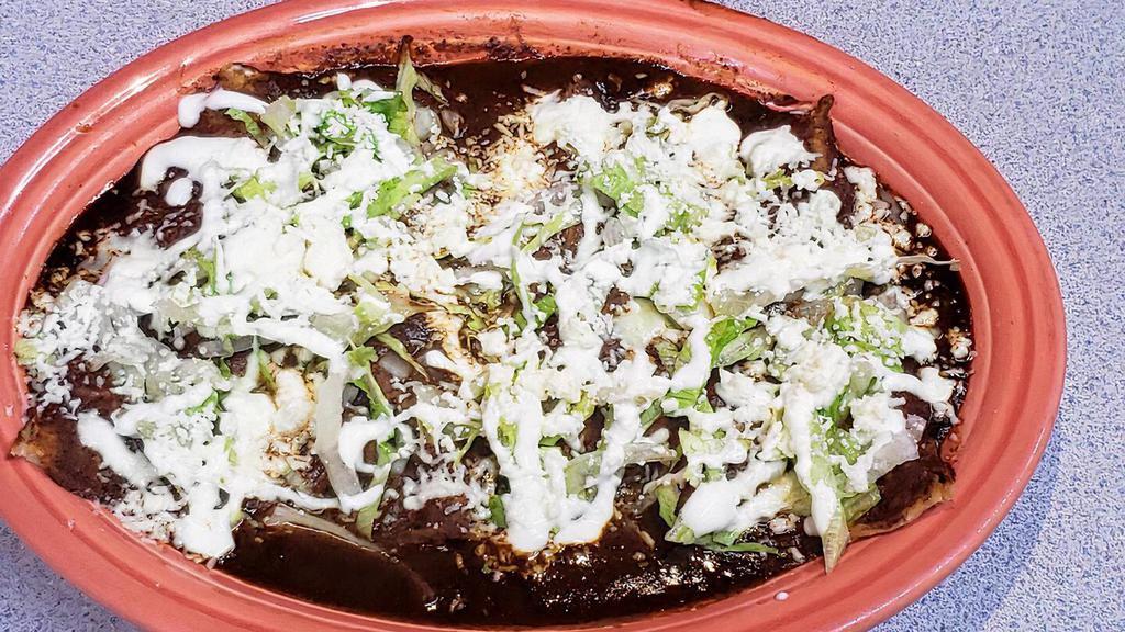 Enchiladas Mole Solas · Four corn tortilla, chicken inside, mole sauce, onion, lettuce, sour cream and fresh crumbling cheese on top. (Mole made with peanuts and chocolate if allergic)