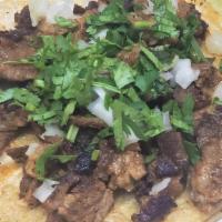 Asada Taco · seasoned steak on a corn tortilla with cilantro and onions. lime and hot sauce on the side.