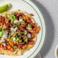 Al Pastor Taco · seasoned pork with pineapple, grill onions, cilantro, lime and hot sauce on the side.