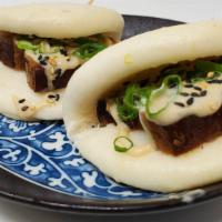 Kakuni Bao · Braised skin-on pork belly in steam buns, served with citrus mayo, scallions and sesame seeds.