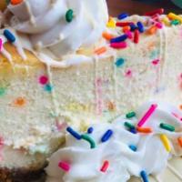 Birthday Cake Cheesecake Slice · A marriage of birthday cake and cheesecake topped with buttercream and sprinkles.
