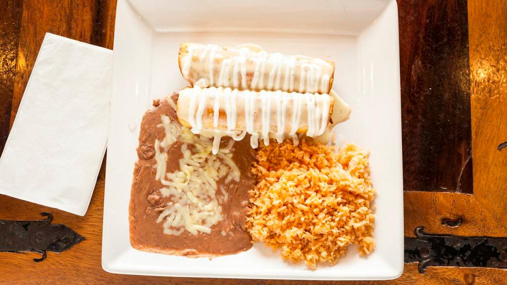 Chimichanga Dinner · Two flour tortillas fried or soft, filled with shredded beef or chicken, drizzled with a cheese sauce and sour cream, served with a side of rice and beans. 700 cal.