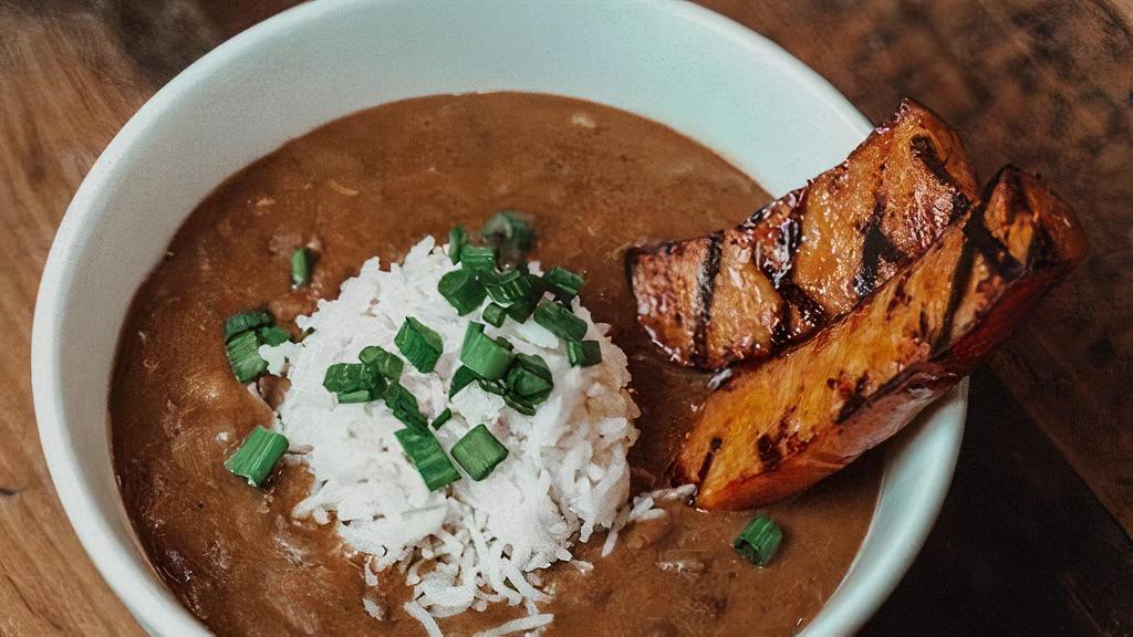 Bowl Red Beans · Red beans simmered in our rich creole broth, rice and garnished with andouille sausage.  There is pork in the base of this dish, not vegetarian.