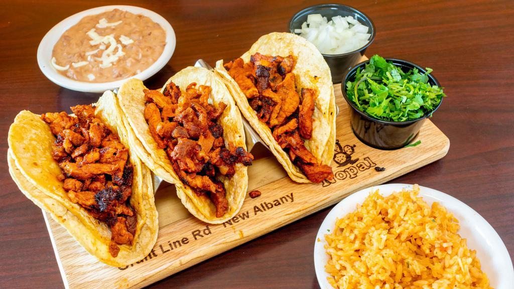 Tacos De Pastor · Three tacos marinated pork, served with rice, beans, lettuce, sour cream and pico de gallo.