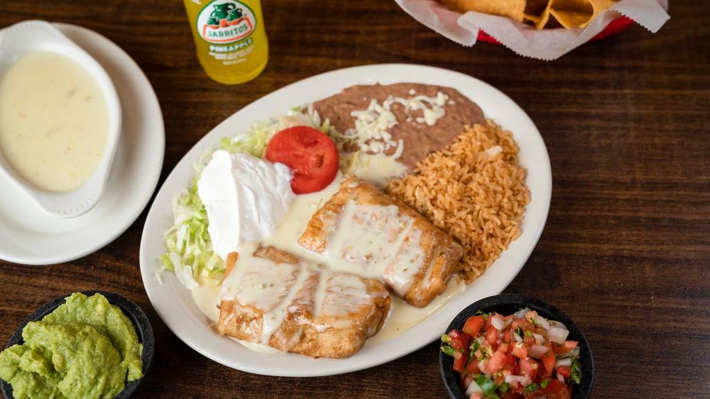 Chimichanga Dinner · (soft or fried) two flour tortillas filled with chicken or beef. Served with rice, beans, topped with white queso, red sauce, lettuce, sour cream, guacamole, and tomato.