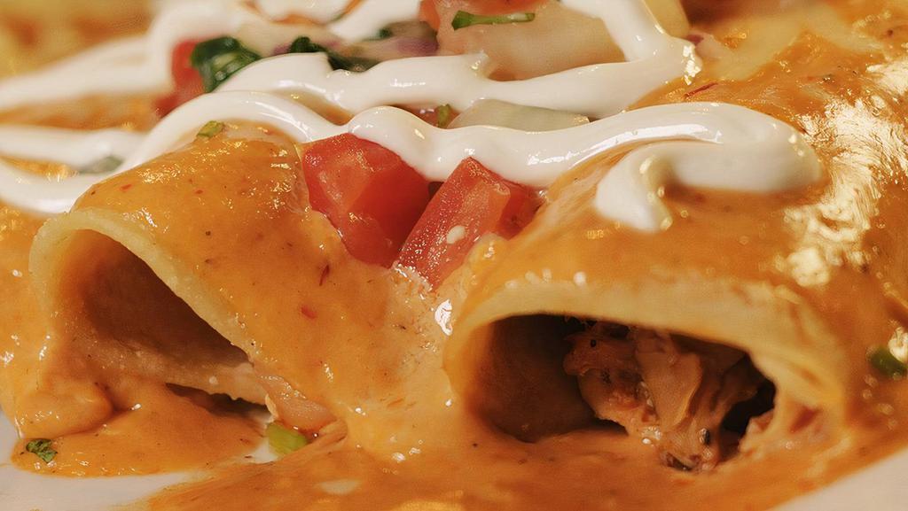 Enchiladas Chipotle · Three shredded chicken enchiladas. Topped with a creamy chipotle sauce, sour cream and pico de gallo. Served with rice and beans.