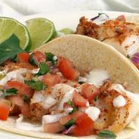 Broiled Trigger Fish Taco · A pleasantly mild fish from the caribbean. Enjoy a pair of buttery light and flaky tacos, dr...