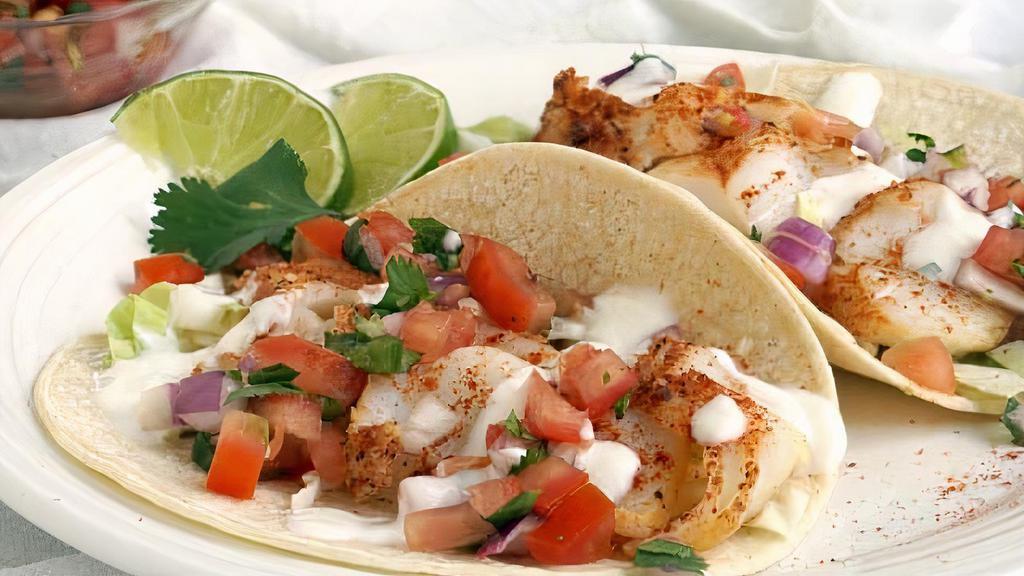 Broiled Trigger Fish Taco · A pleasantly mild fish from the caribbean. Enjoy a pair of buttery light and flaky tacos, drizzled with lime and served on top of mixed greens topped with salsa.