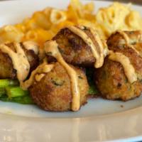 Mini Crab Cakes · Light savory starter that satisfies without being too filling. 6 crab bites on a bed of gree...