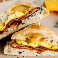 Deluxe Breakfast Sandwich · Farm fresh scrambled eggs, aged cheddar, choice of bacon, ham or sausage, served with a side...