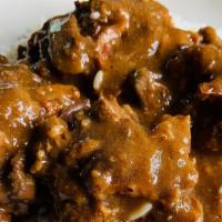 Oxtails · Oxtails in gravy on rice with two sides.