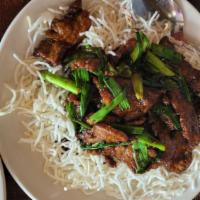 Mongolian Beef · Sliced beef sautéed in Mongolian sauce and scallion onions, over a bed of crispy noodles.
