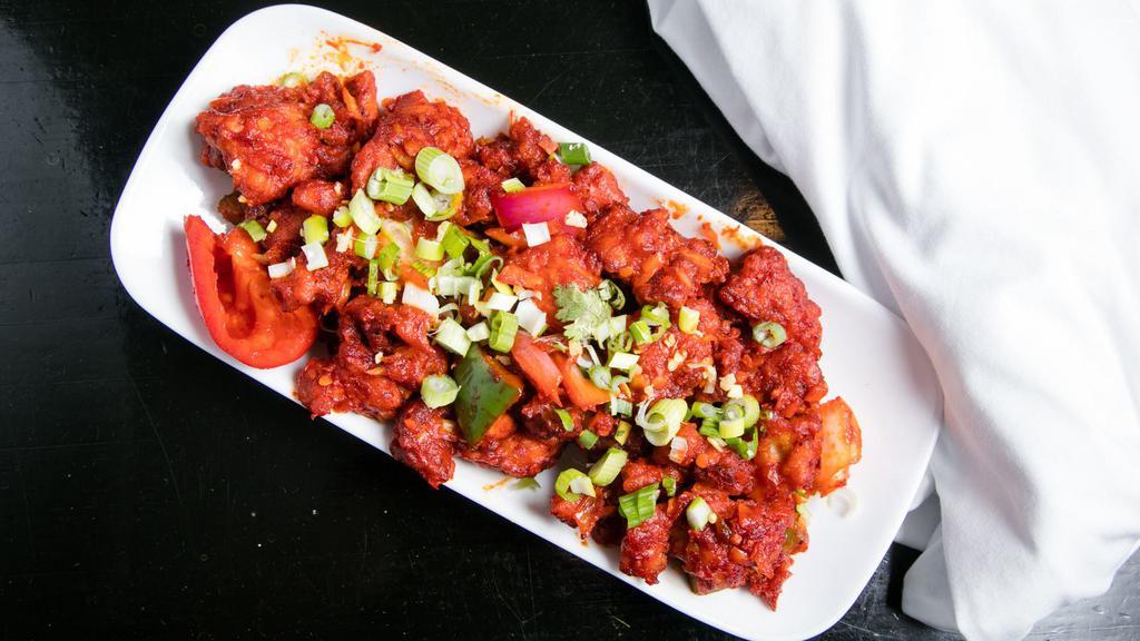 Chilli Chicken · Battered chicken cooked with spices and herbs, tomato, vinegar, soy sauce, and spicy red chilli sauce.